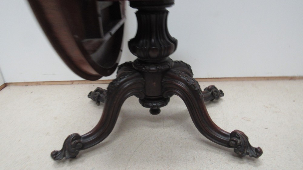 A circular Victorian walnut occasional table featuring intricate floral marquetry inlay along the border and central medallion, supported on a carved tripod pedestal base. View XV