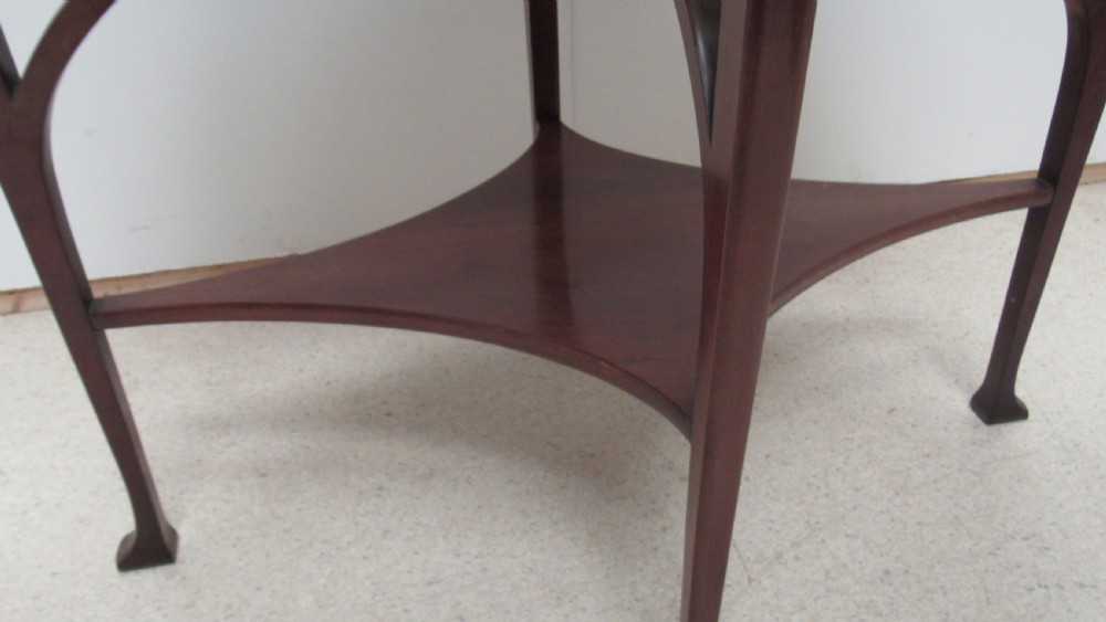 An oval dark mahogany occasional table featuring a central decorative marquetry inlay, sweeping curved legs, and a small shaped lower tier. View VI