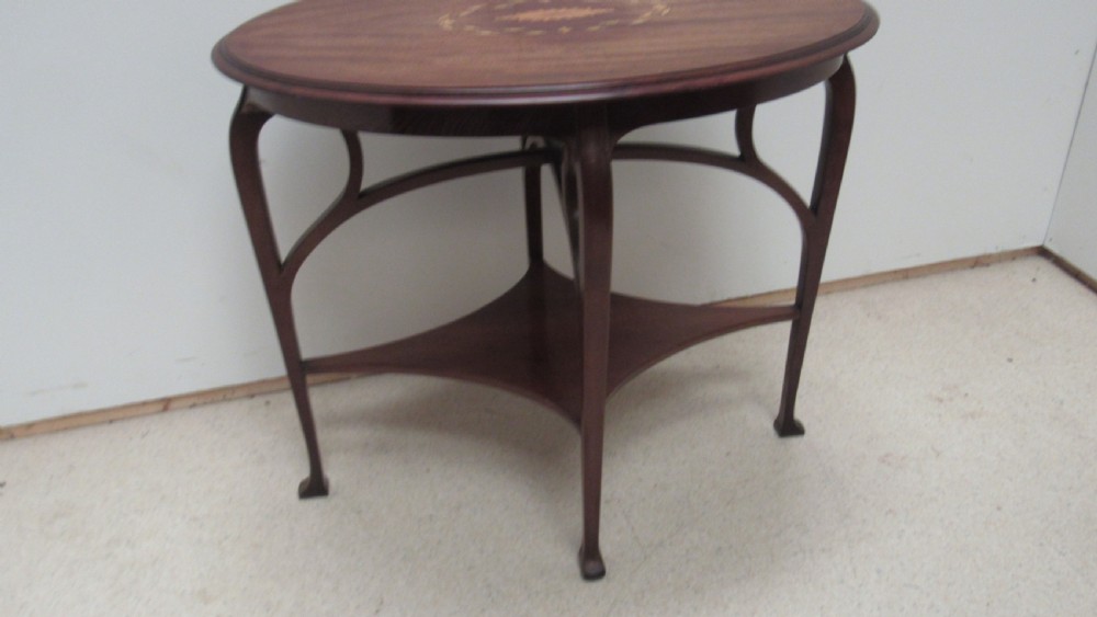 An oval dark mahogany occasional table featuring a central decorative marquetry inlay, sweeping curved legs, and a small shaped lower tier. View XI