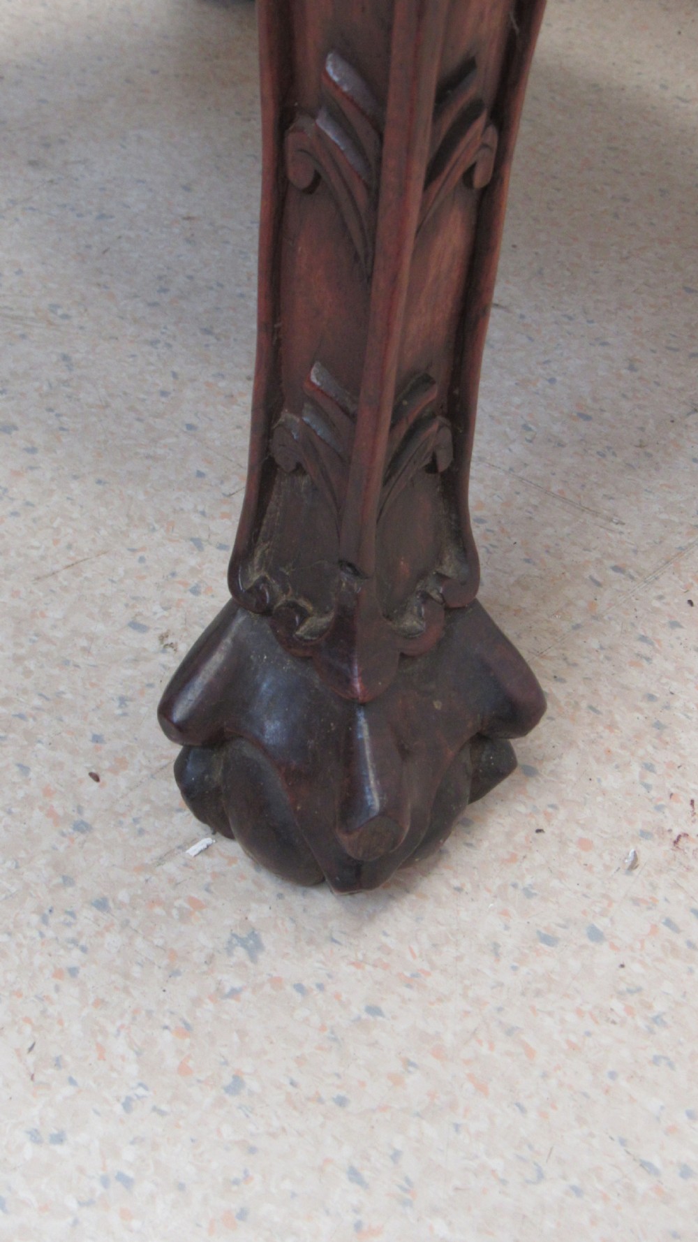 A circular dark wood urn stand featuring an inset pink marble top, detailed relief carving on the apron, curved cabriole legs, and a lower shelf. View IX