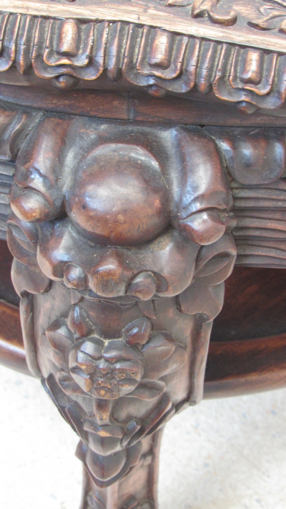 A circular dark wood urn stand featuring an inset pink marble top, detailed relief carving on the apron, curved cabriole legs, and a lower shelf. View XIV