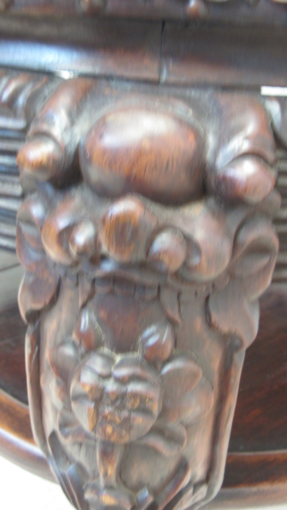 A circular dark wood urn stand featuring an inset pink marble top, detailed relief carving on the apron, curved cabriole legs, and a lower shelf. View XV