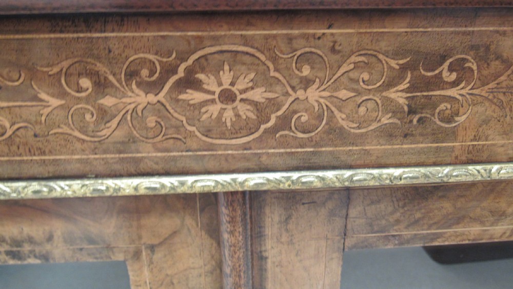 A 19th-century Victorian burr walnut pier cabinet featuring floral marquetry inlay, glazed double doors, glass shelves, and gilt brass corner mounts. View IX