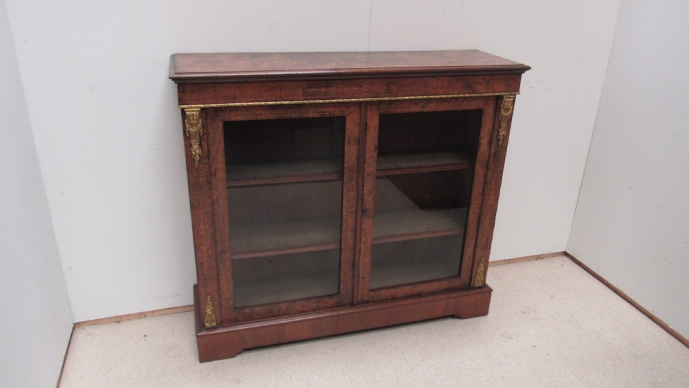 A 19th-century Victorian burr walnut pier cabinet featuring floral marquetry inlay, glazed double doors, glass shelves, and gilt brass corner mounts. View XI