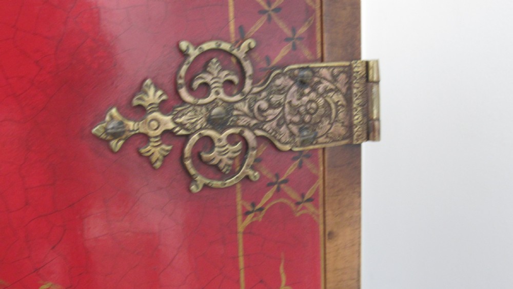 A red lacquered chinoiserie cocktail cabinet decorated with gilt landscapes and figures, featuring ornate brass hinges and set on a carved timber stand with cabriole legs. View XIII