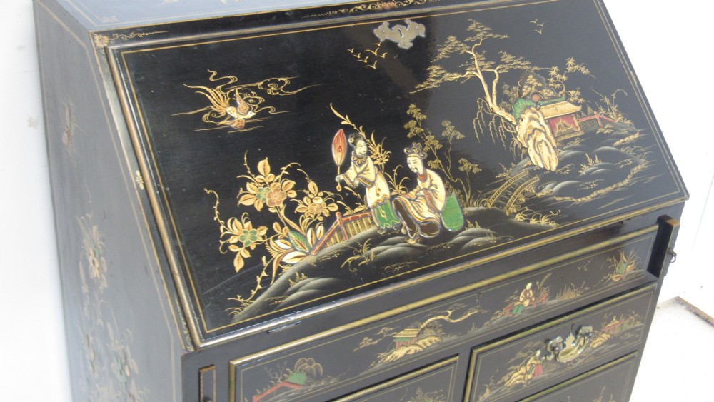 A black lacquered slant-front writing bureau decorated with detailed gold chinoiserie figurative landscapes and fitted with multiple drawers. View III