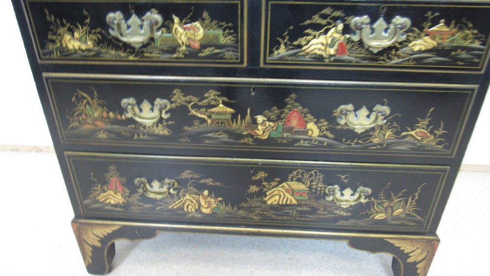 A black lacquered slant-front writing bureau decorated with detailed gold chinoiserie figurative landscapes and fitted with multiple drawers. View IV