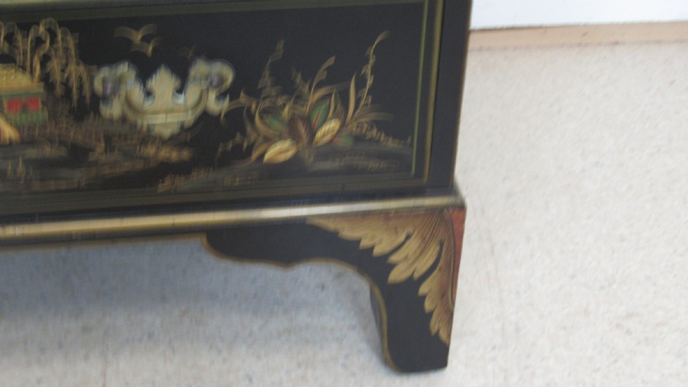 A black lacquered slant-front writing bureau decorated with detailed gold chinoiserie figurative landscapes and fitted with multiple drawers. View V