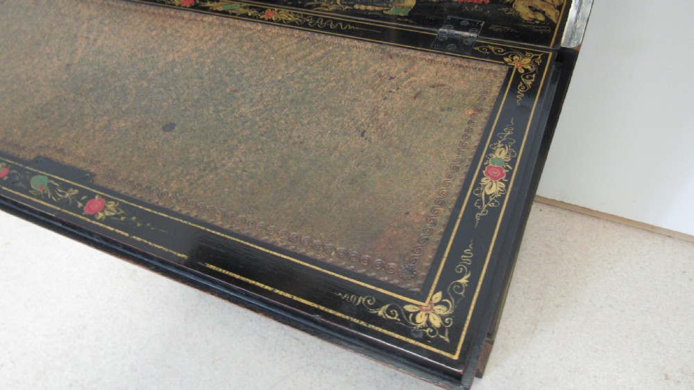A black lacquered slant-front writing bureau decorated with detailed gold chinoiserie figurative landscapes and fitted with multiple drawers. View VII
