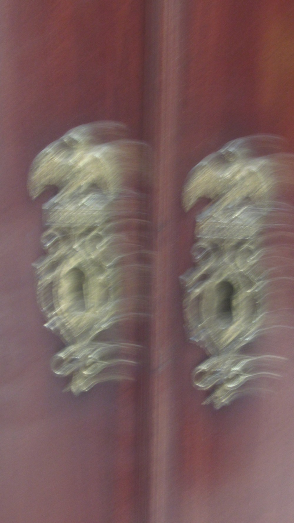 An antique Georgian bowfront corner cupboard crafted from dark mahogany with twin doors, brass H-hinges, and decorative escutcheons. View III