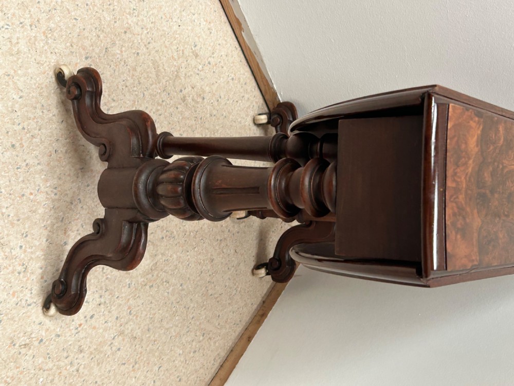 A Victorian burr walnut baby Sutherland drop-leaf side table featuring turned support pillars, carved feet, and ceramic castors. View III