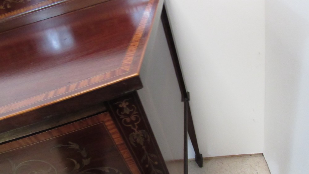 An antique mahogany sideboard with central drawer and side cupboards decorated with fine floral marquetry inlay on tapered legs. View VIII