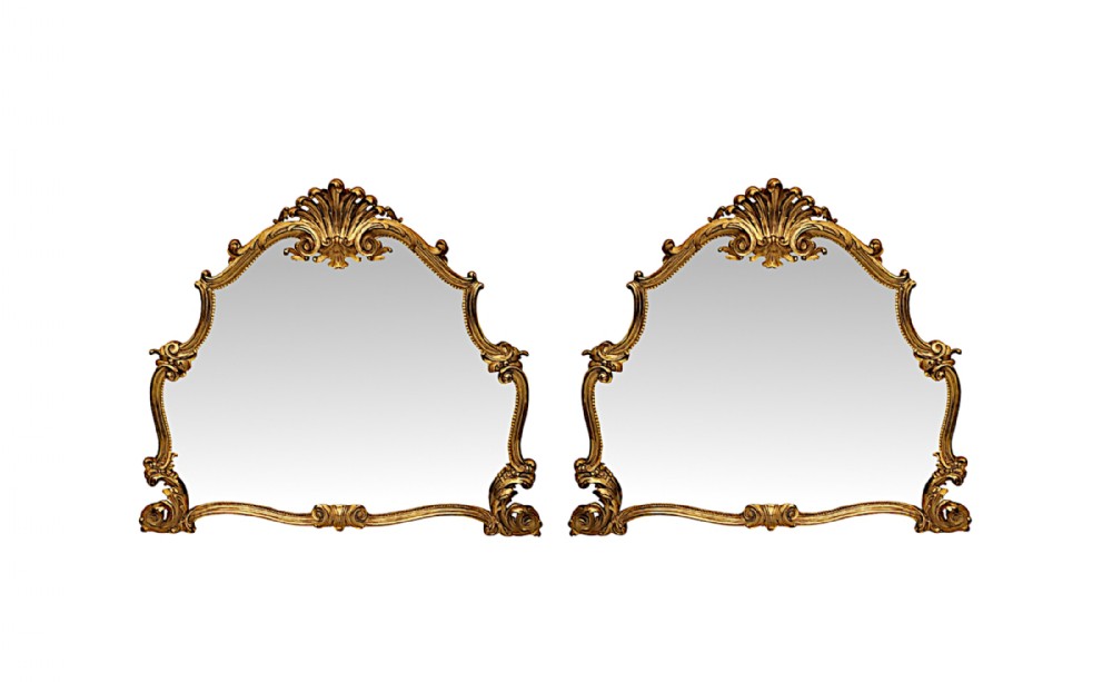 A pair of nineteenth-century Italian giltwood overmantel mirrors with carved scrollwork and shell crestings.