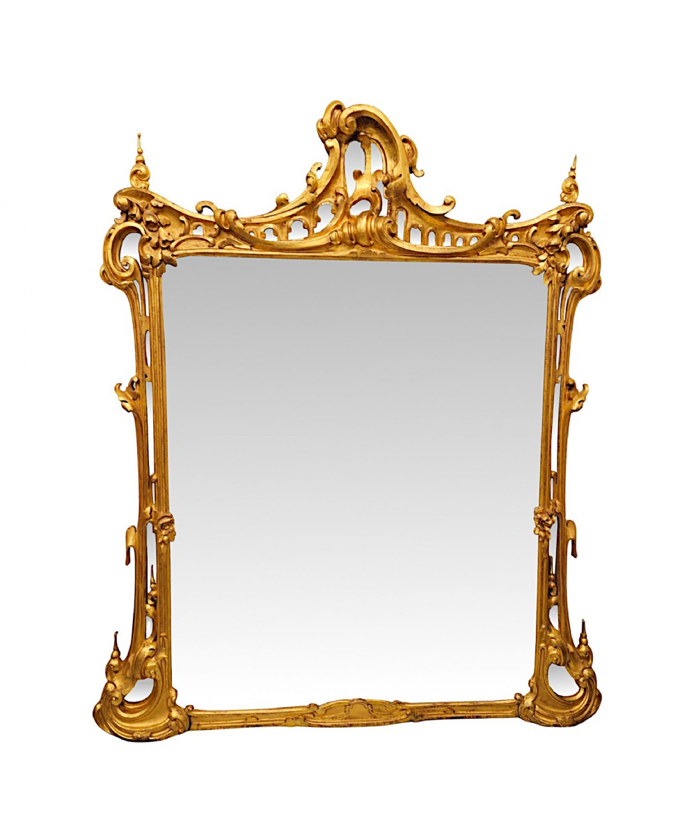 An ornate 19th-century Chinese Chippendale style overmantel mirror featuring intricate gilded wood carving with scrollwork and pagoda motifs.