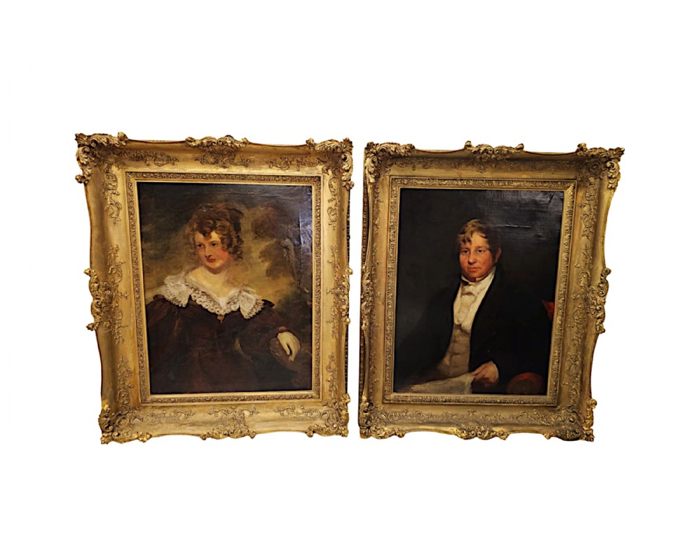 A pair of 19th-century oil portrait paintings depicting a gentleman and a lady, housed within ornate swept giltwood frames with foliate scrolling.