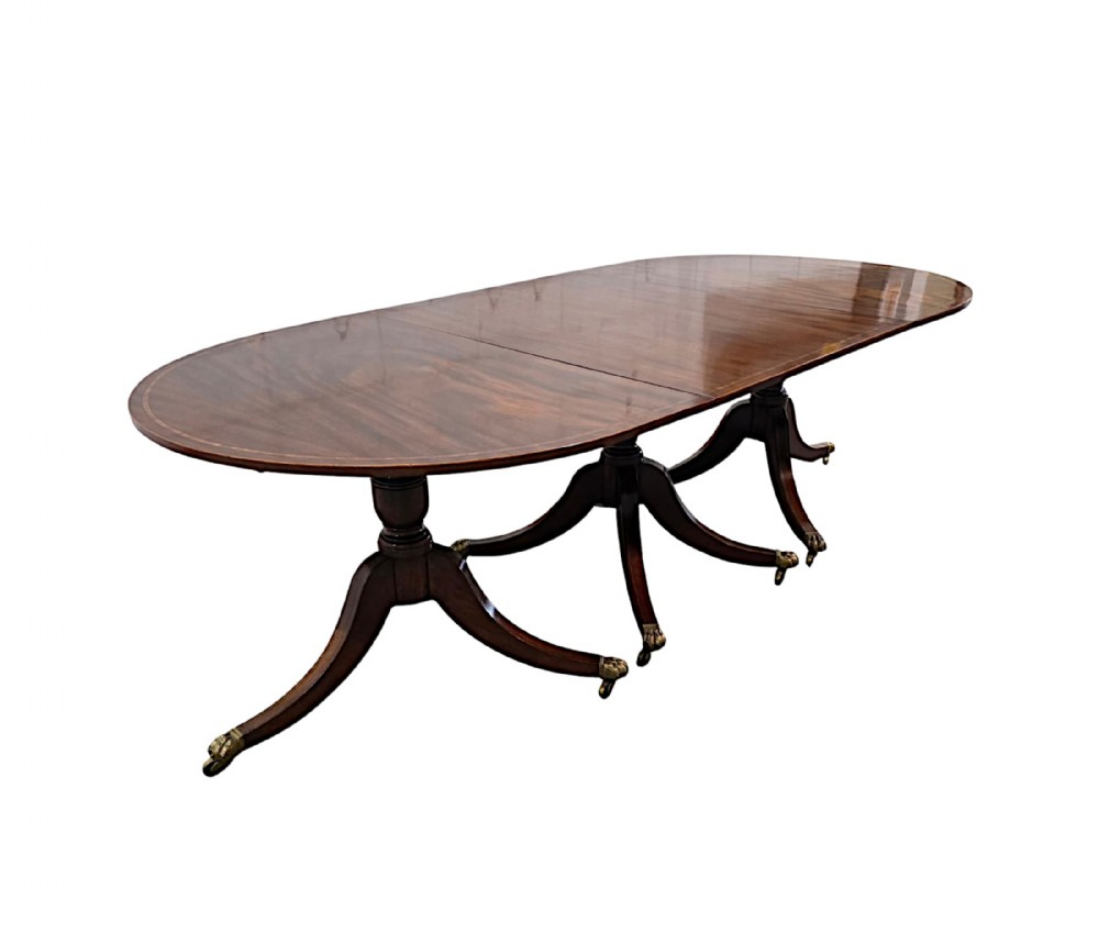 A late nineteenth-century mahogany D-end dining table featuring three pedestal supports with swept legs and brass castors.