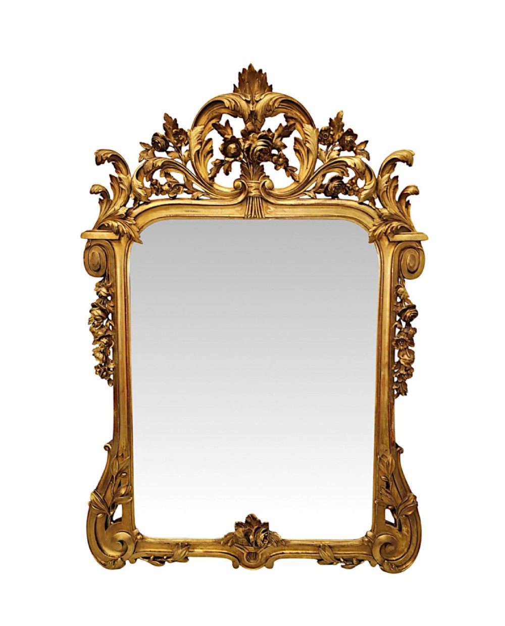 An ornate 19th-century giltwood wall mirror featuring carved floral cresting, acanthus leaf scrolls, and a rectangular mirror plate.