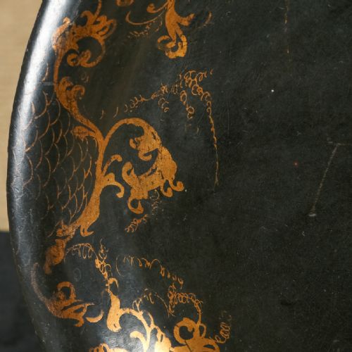 fig 3. An oval ebonised papier-mache serving tray featuring a hand-painted floral bouquet centrepiece surrounded by gilt scrollwork detailing along the rim.