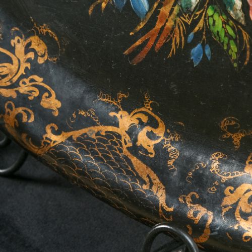 fig 4. An oval ebonised papier-mache serving tray featuring a hand-painted floral bouquet centrepiece surrounded by gilt scrollwork detailing along the rim.