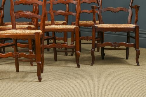 fig 6. A set of eight French provincial oak dining chairs featuring wavy ladder backrests, hand-woven rush seats, and carved cabriole legs.