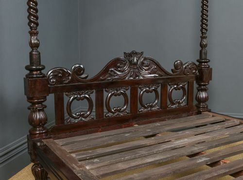 fig 5. A dark brown Anglo-Indian colonial four poster bed with spiral turned posts and a carved wooden footboard.