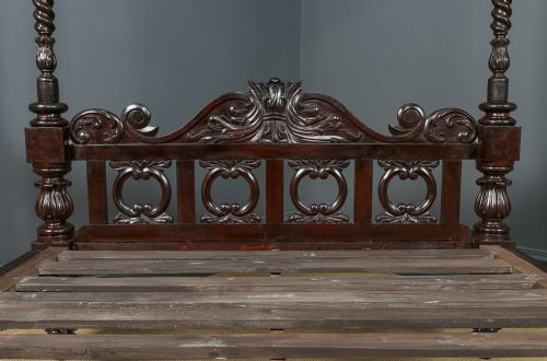 fig 6. A dark brown Anglo-Indian colonial four poster bed with spiral turned posts and a carved wooden footboard.