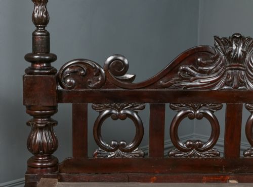fig 7. A dark brown Anglo-Indian colonial four poster bed with spiral turned posts and a carved wooden footboard.