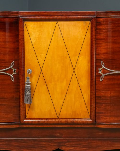 fig 3. An Art Deco mahogany sideboard featuring a serpentine front, central diamond parquetry door in maple, and streamlined metal handles.