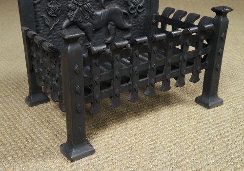 fig 9. A black cast iron fire grate featuring a relief-carved heraldic lion backplate and portcullis lattice front basket.