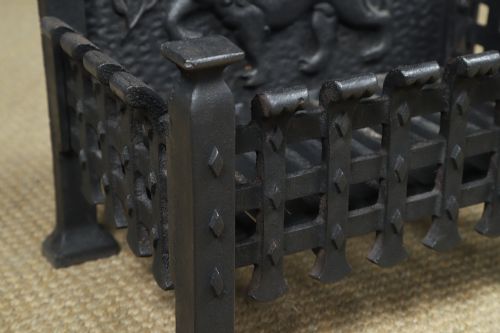 fig 10. A black cast iron fire grate featuring a relief-carved heraldic lion backplate and portcullis lattice front basket.