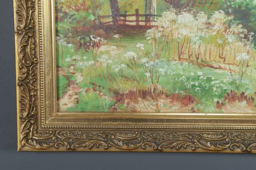fig 2. A framed landscape painting depicting a serene river flowing through green foliage and trees, presented in an ornate gilt frame.