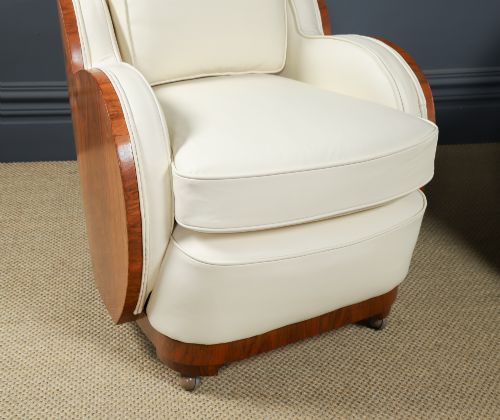 fig 3. An antique Art Deco three-piece lounge suite consisting of a three-seater sofa and two matching armchairs upholstered in cream leather with curved walnut side panels.