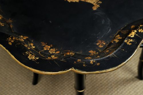 fig 7. An ebonised Victorian papier-mache tray table featuring gilt Chinoiserie decoration and a lion motif, resting on a faux-bamboo base.