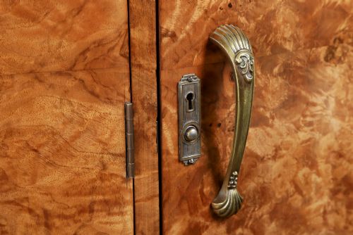fig 3. An English Art Deco triple-door wardrobe crafted from figured burr walnut with curved sides and vertical handles.