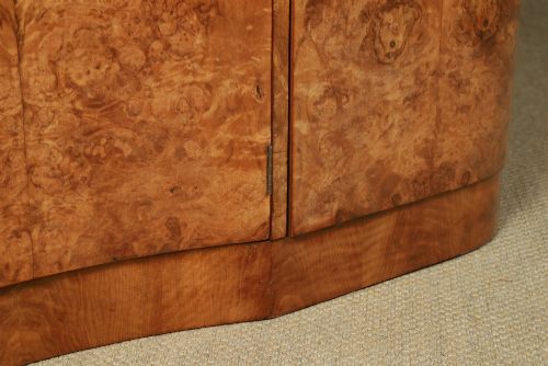 fig 4. An English Art Deco triple-door wardrobe crafted from figured burr walnut with curved sides and vertical handles.