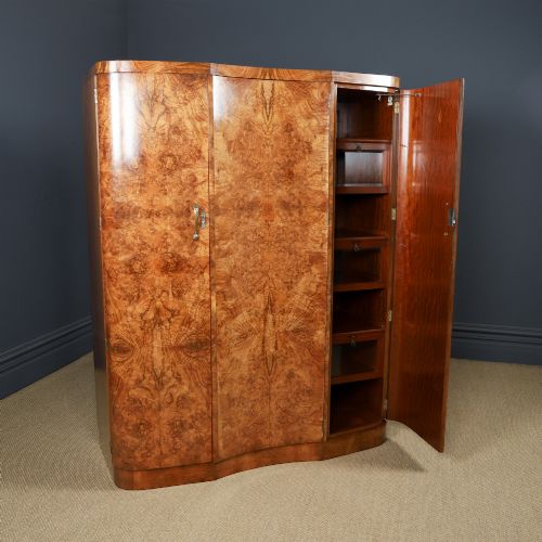 fig 5. An English Art Deco triple-door wardrobe crafted from figured burr walnut with curved sides and vertical handles.