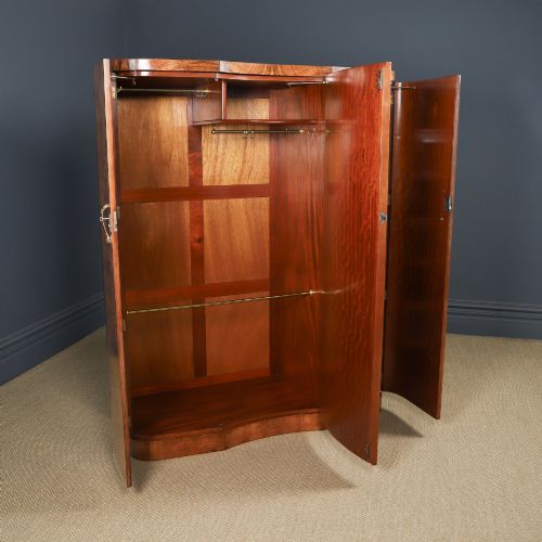 fig 6. An English Art Deco triple-door wardrobe crafted from figured burr walnut with curved sides and vertical handles.