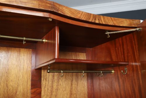 fig 7. An English Art Deco triple-door wardrobe crafted from figured burr walnut with curved sides and vertical handles.