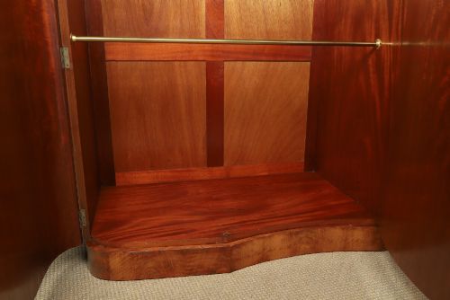 fig 8. An English Art Deco triple-door wardrobe crafted from figured burr walnut with curved sides and vertical handles.