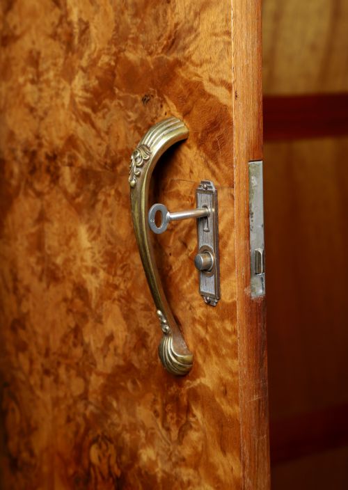 fig 9. An English Art Deco triple-door wardrobe crafted from figured burr walnut with curved sides and vertical handles.