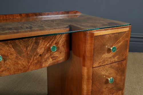 fig 3. An Art Deco burr walnut pedestal writing desk with green circular knobs and a fitted glass top.