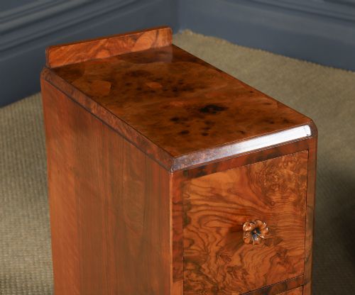 fig 1. A pair of narrow Art Deco burr walnut bedside cabinets featuring two drawers with carved circular handles and a low back ledge.