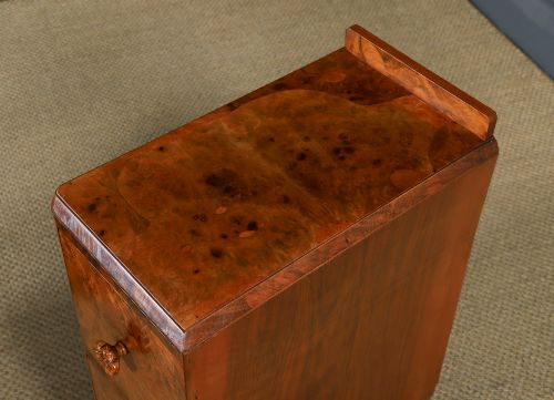 fig 5. A pair of narrow Art Deco burr walnut bedside cabinets featuring two drawers with carved circular handles and a low back ledge.