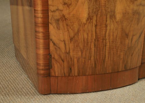 fig 1. An Art Deco walnut two door wardrobe featuring a bow front design, carved wood handles, and figured timber grain.