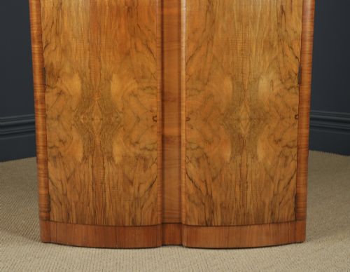 fig 6. An Art Deco walnut two door wardrobe featuring a bow front design, carved wood handles, and figured timber grain.
