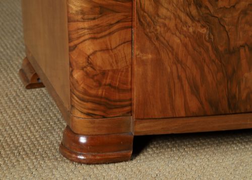 fig 3. An Art Deco two door wardrobe crafted from warm brown figured walnut veneer with a gently curved bow front and wooden vertical handles.
