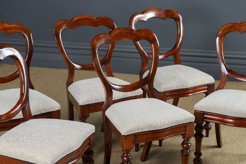 fig 3. A set of six Victorian mahogany dining chairs featuring open balloon-shaped backs, turned front legs, and neutral upholstered seats.