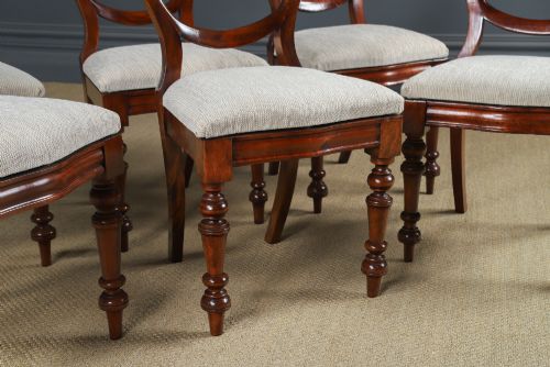 fig 4. A set of six Victorian mahogany dining chairs featuring open balloon-shaped backs, turned front legs, and neutral upholstered seats.