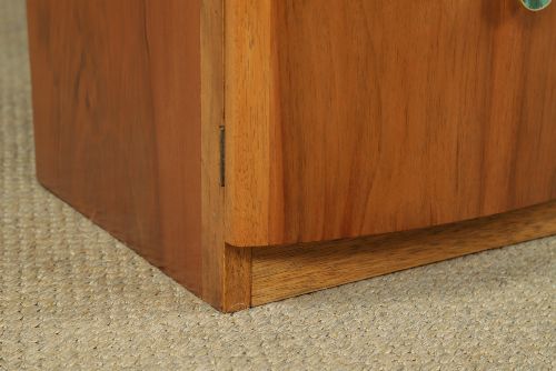 fig 2. A pair of Art Deco walnut bedside tables with an upper open compartment and a lower cupboard featuring a round green handle.