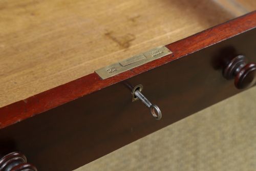 fig 6. An antique rectangular dark mahogany low coffee table featuring a single drawer with two turned handles and a brass keyhole.